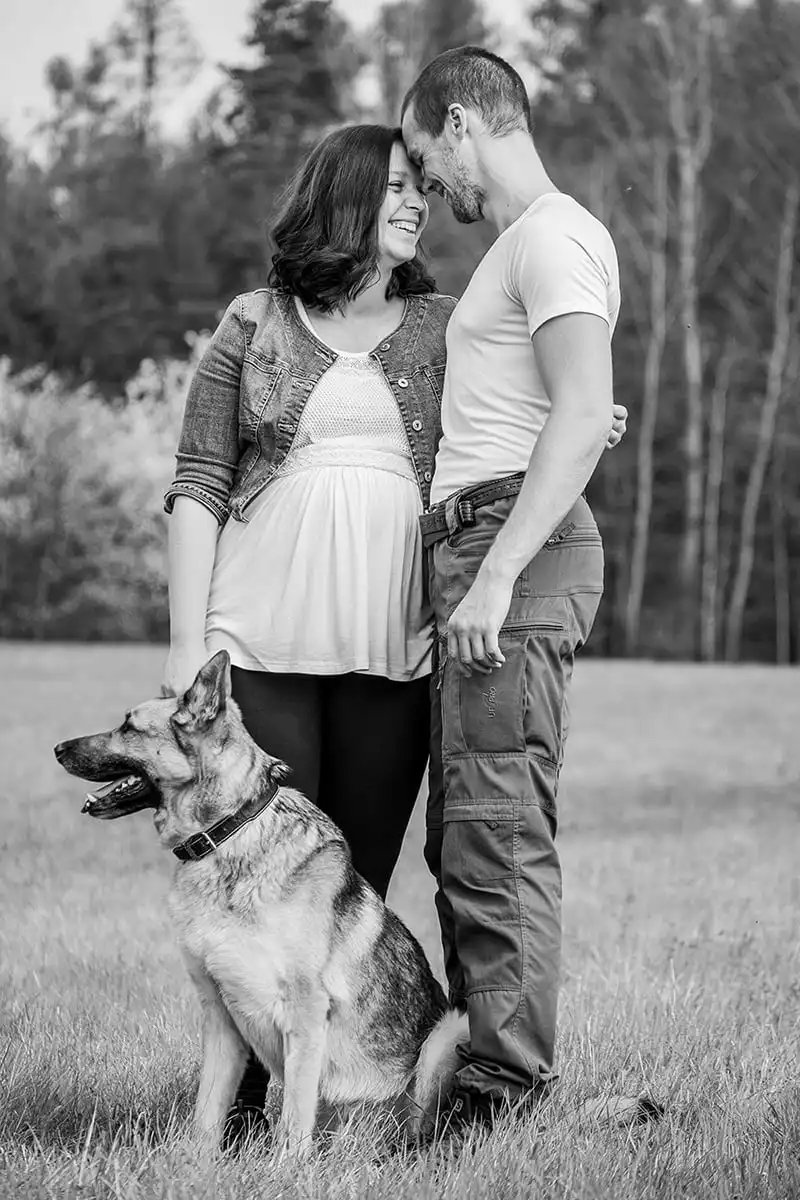 Pózující těhotná žena, muž a pes